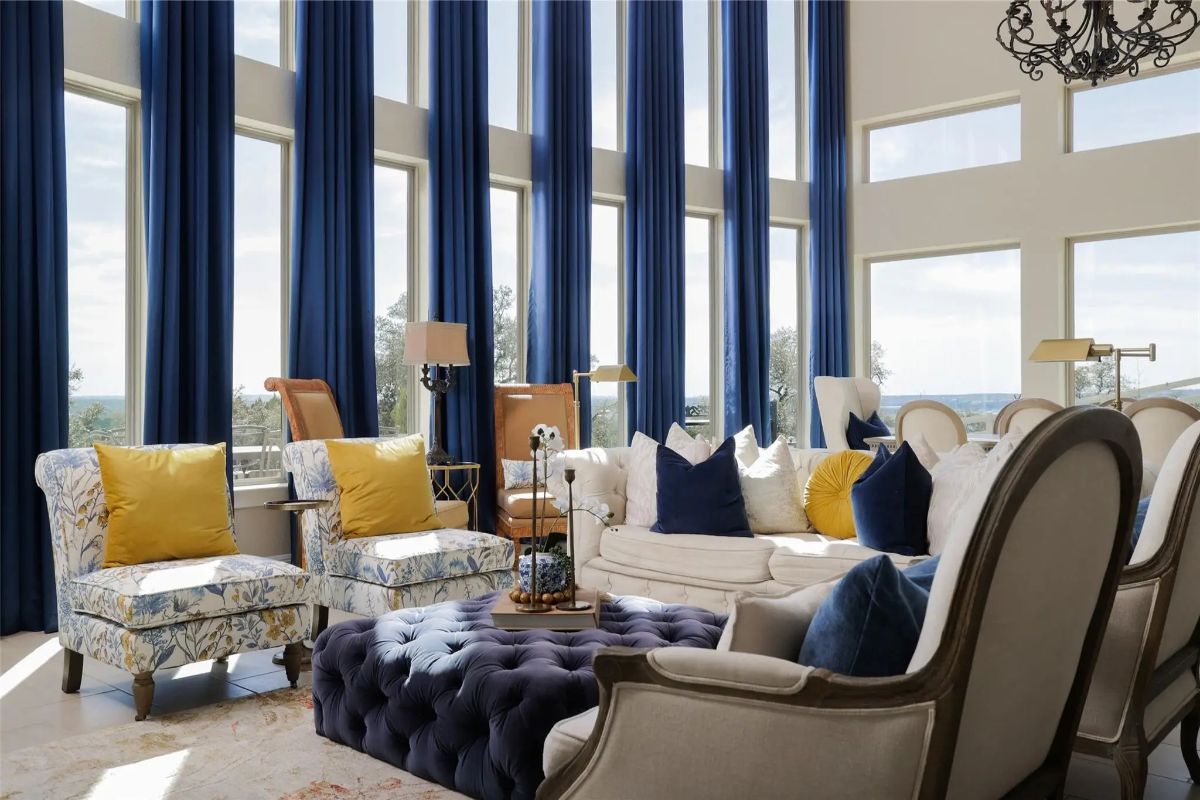 Two tall armchairs and patterned side chairs frame a tufted ottoman.