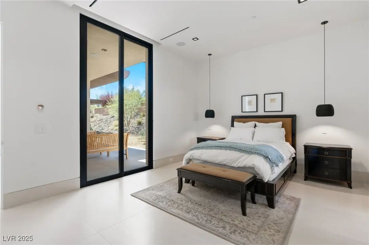 Bedroom with sliding glass door, black-framed accents, and neutral decor. 