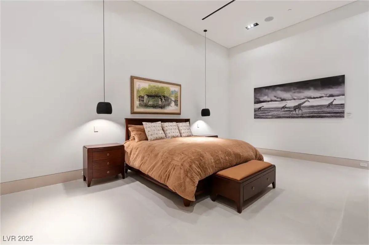 Second bedroom with brown bedding, wall art, and pendant lighting. 