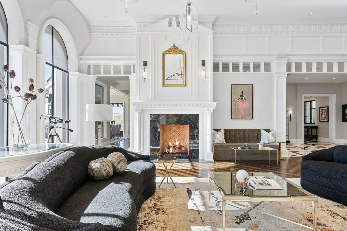 Fireplace-centered seating area with ornate trim work and mixed classical and modern furnishings. 