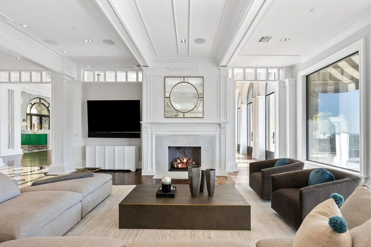 Lounge with fireplace, built-in TV, and a blend of neutral furnishings and classic millwork. 