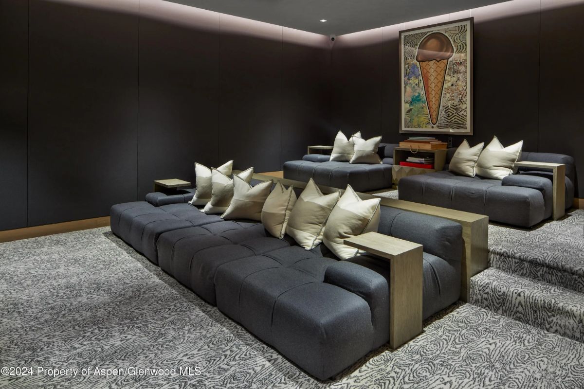 Home theater with tiered cushioned seating and dark walls. 