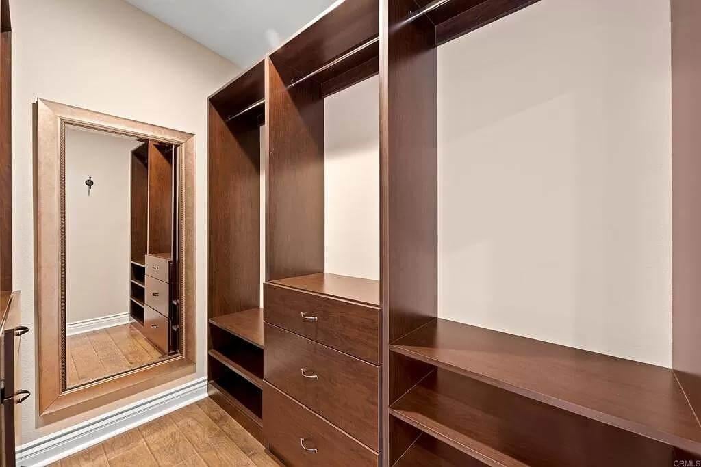 Discover the Rich Wood Tones in this Spacious Walk-In Closet
