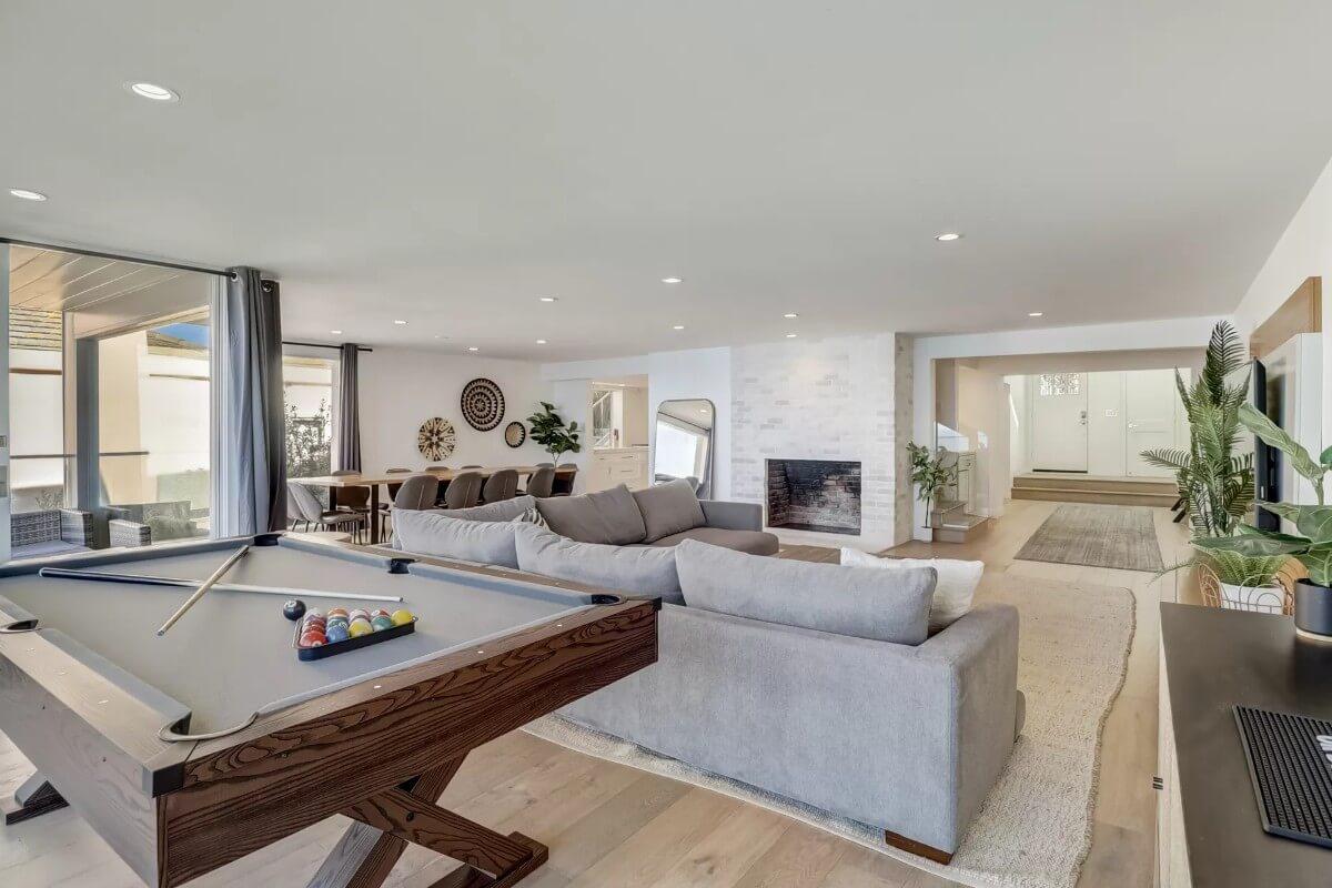 Spacious Living Area with a Pool Table and Modern Fireplace