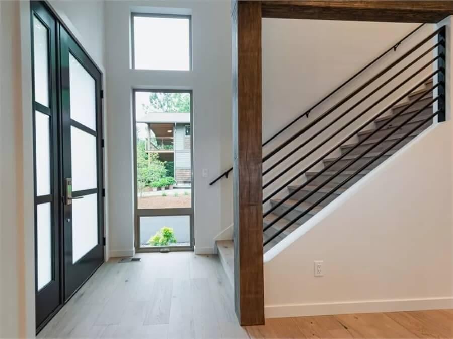 Check Out the Stylish Contrast of the Metal Railings and Wooden Beam in This Entryway