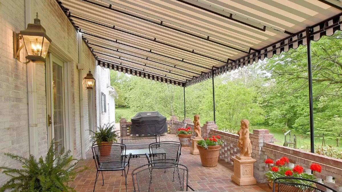 Charming Patio with Striped Awning and Brick Detailing