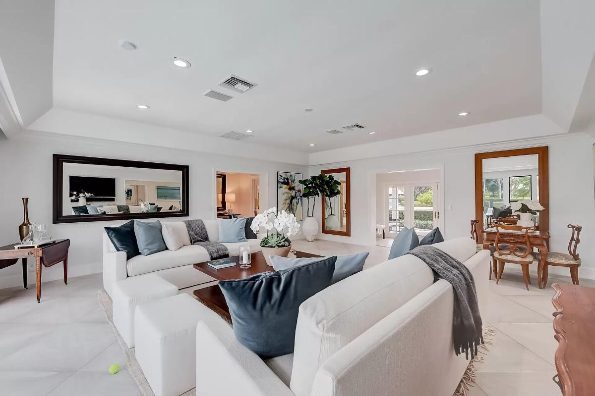 Spacious Living Room with Dual Mirrors Reflecting Light and Life