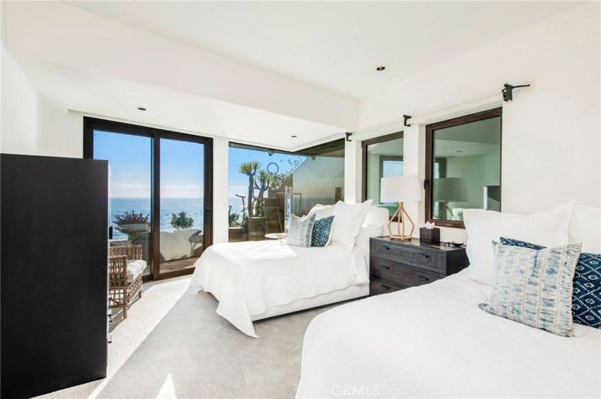Twin beds are positioned to face sliding doors leading to an outdoor area.