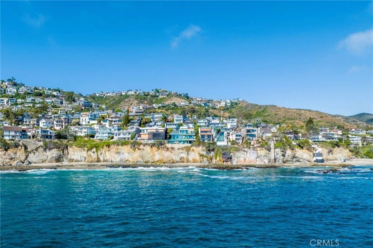 Homes line the edge of a steep coastal bluff overlooking the ocean.