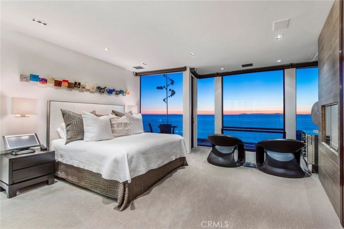 Bed is centered on a wall with built-in lighting and abstract art.
