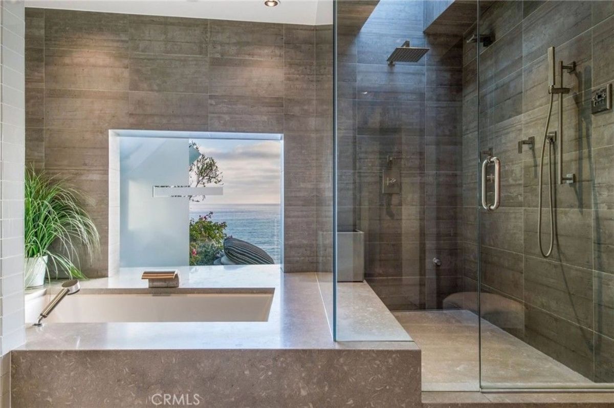 Soaking tub sits below a picture window facing the ocean.