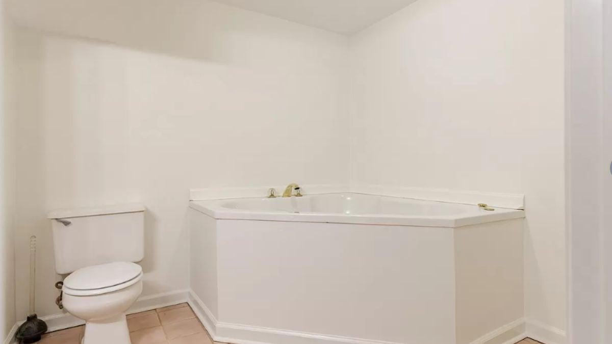 Simple Bathroom with Corner Tub and Clean Aesthetic