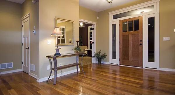 Welcoming Entryway with Warm Wood Tones and Glass-Paneled Door