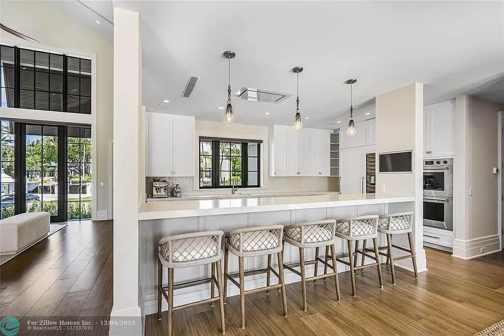 Wide Counter with Pendant Lighting Steals the Show in This Sleek Kitchen