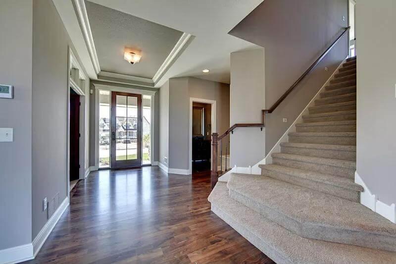 Grand Entrance with Elegant Staircase and Warm Wood Floors