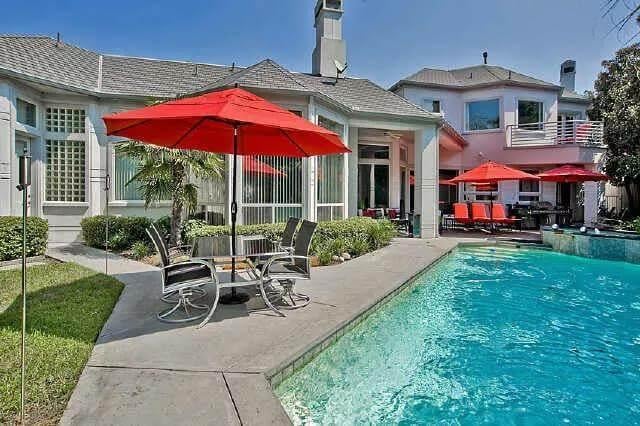 Dive into This Backyard Oasis with Vibrant Red Umbrellas