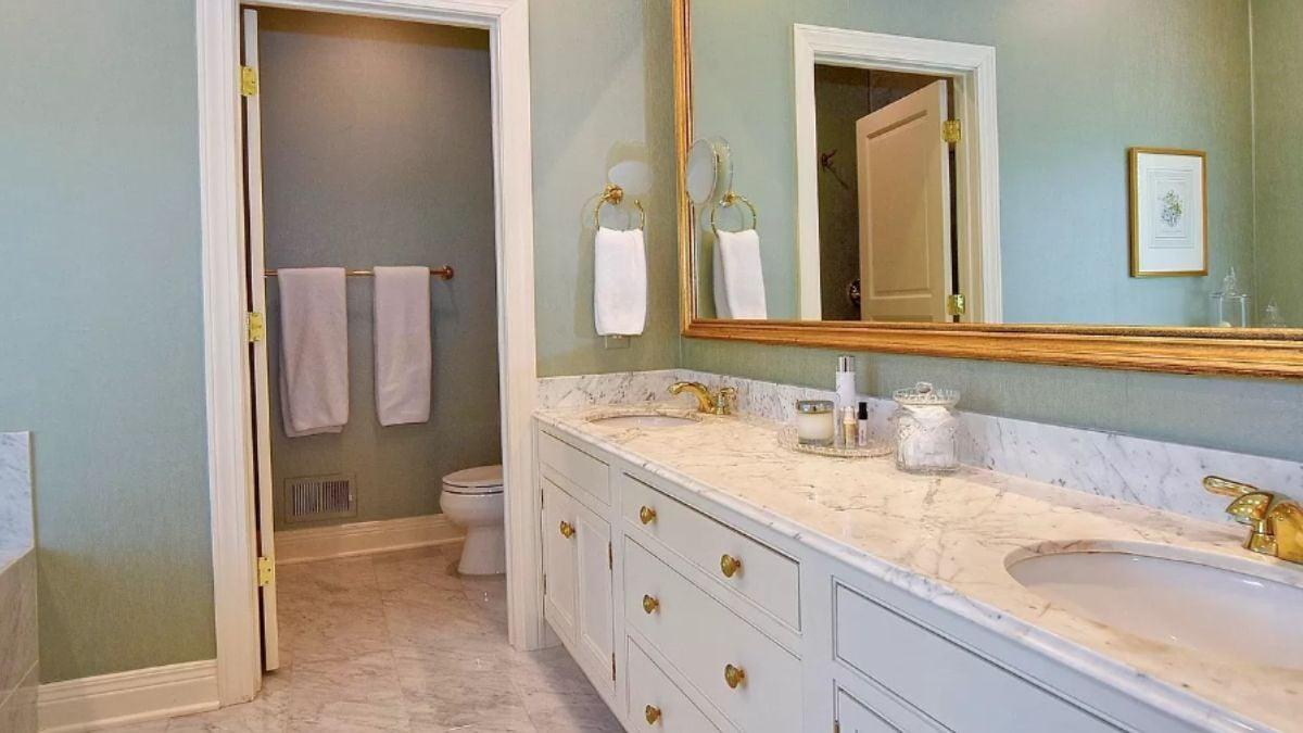Notice the Gold Fixtures and Marble Countertops in This Elegant Bathroom