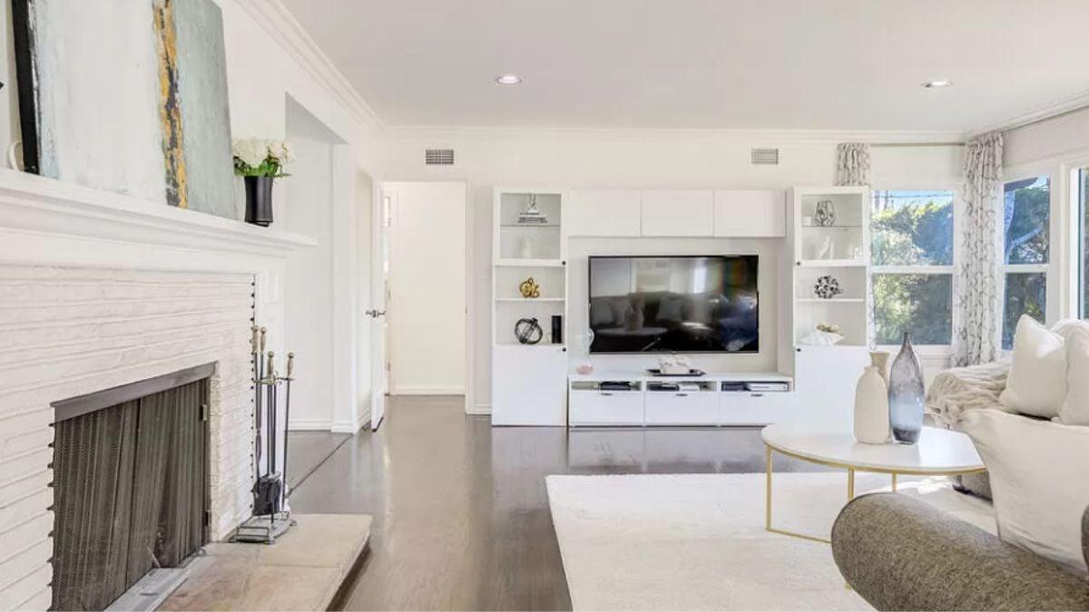 Contemporary Living Room with Crisp White Shelving and Artful Fireplace