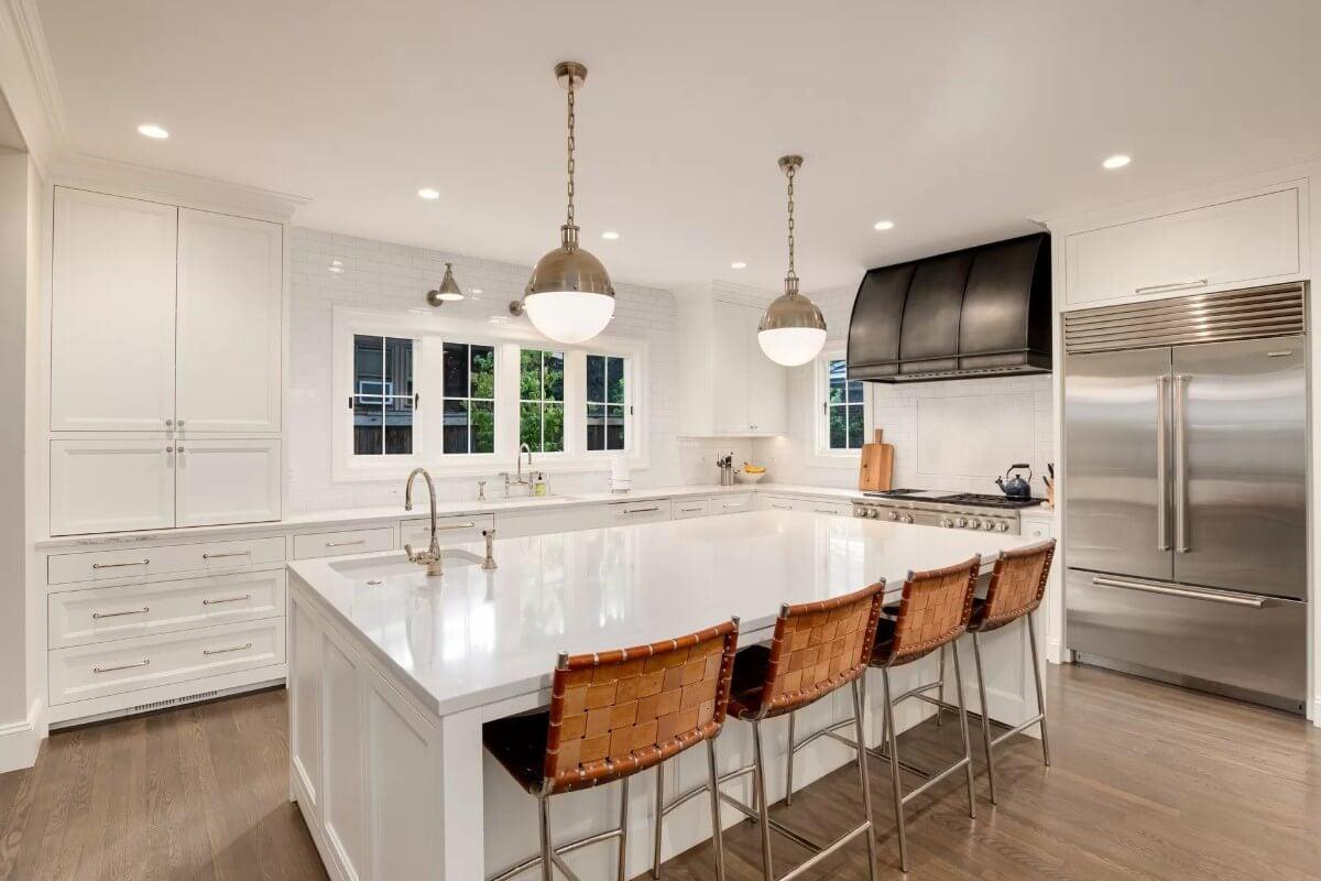 Check Out This Sleek Kitchen With Its Oversized Island and Leather-Stitched Bar Stools