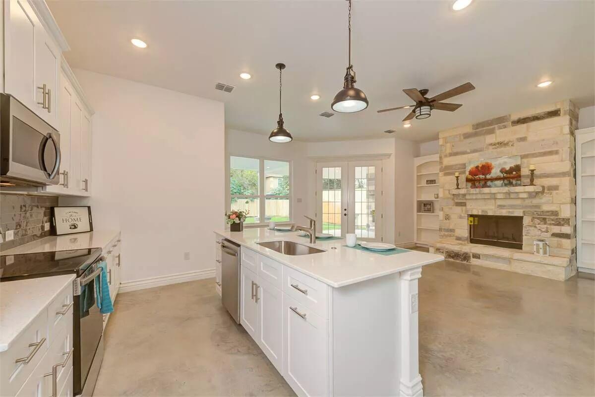 Warm Kitchen Overlooking Inviting Living Area with Stone Fireplace