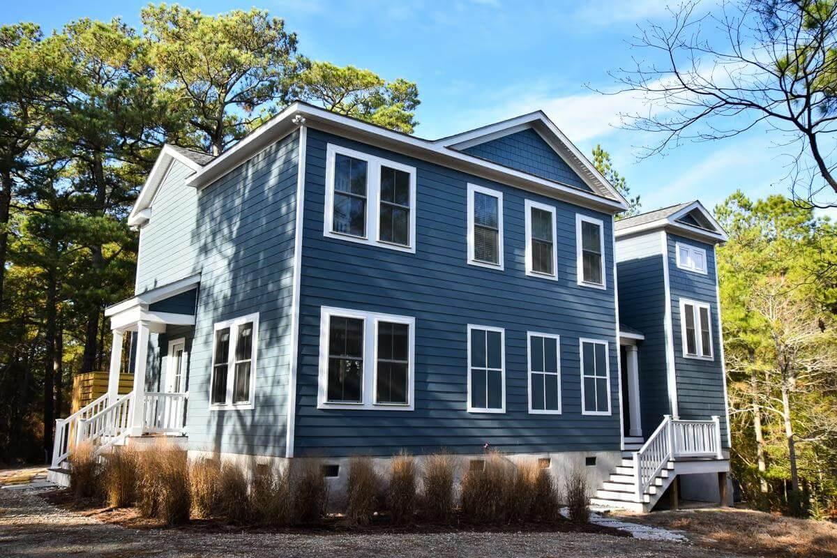 Explore This Classic Blue Siding Home Amidst Tall Pines