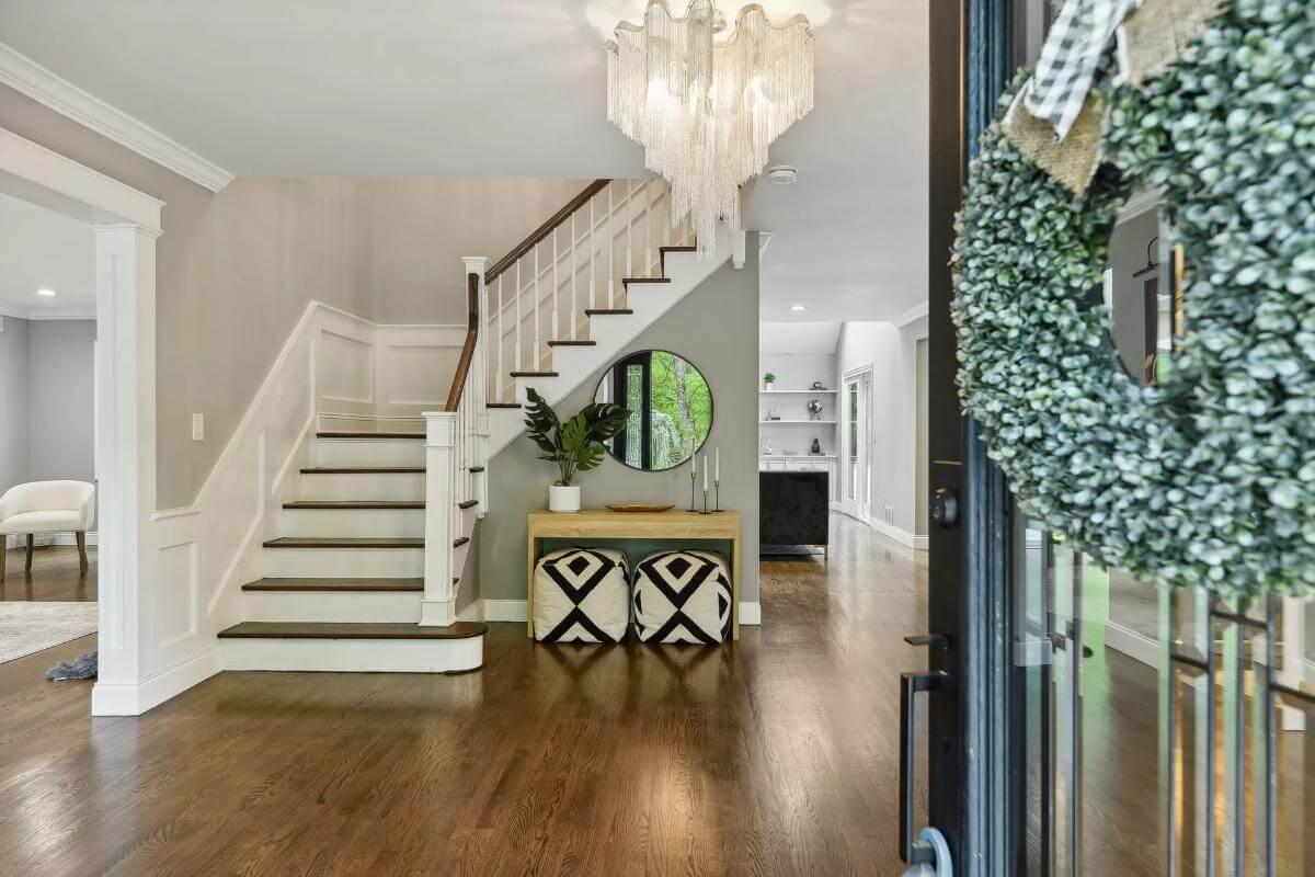Grand Entrance with Elegant Staircase and Dramatic Chandelier