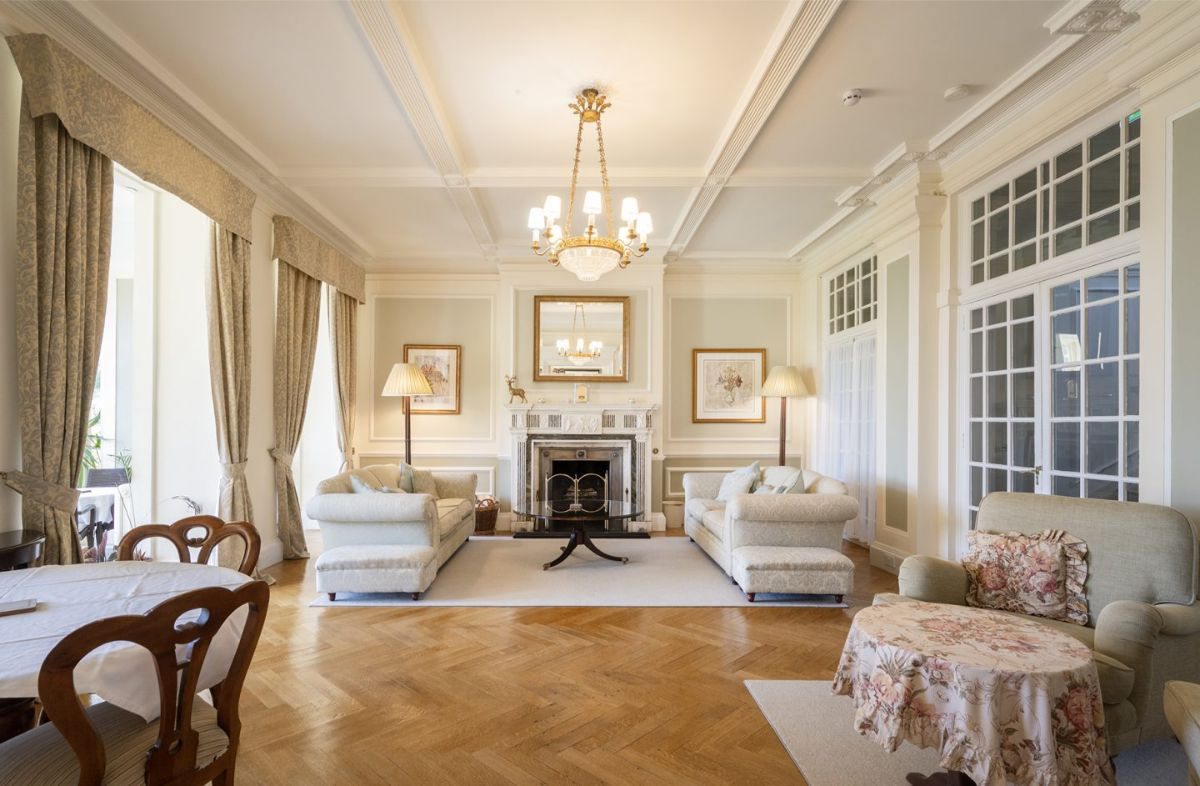Two white sofas face each other in front of a traditional fireplace.