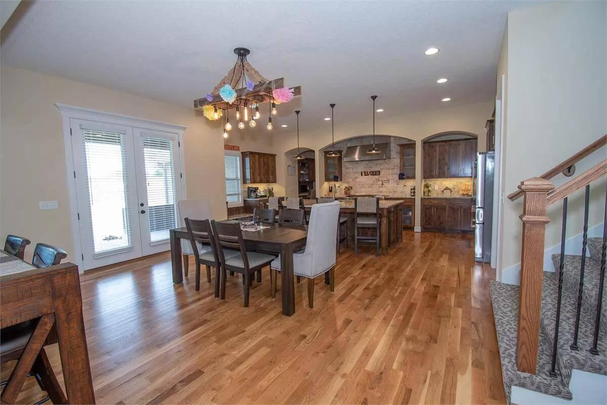 Explore This Inviting Kitchen and Dining Area with Its Distinctive Light Fixture