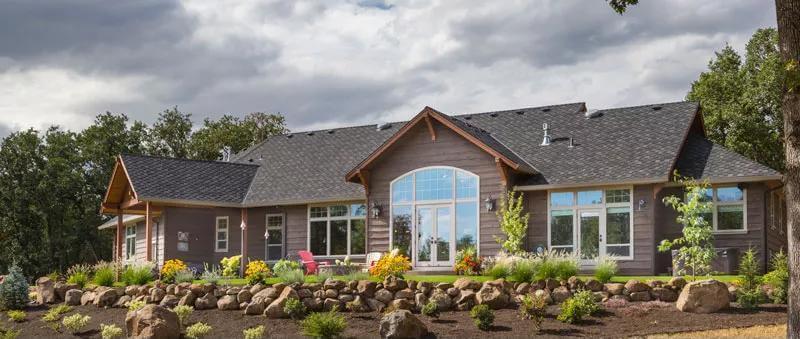 Admire the Expansive Windows and Stone Landscaping in This Craftsman Gem
