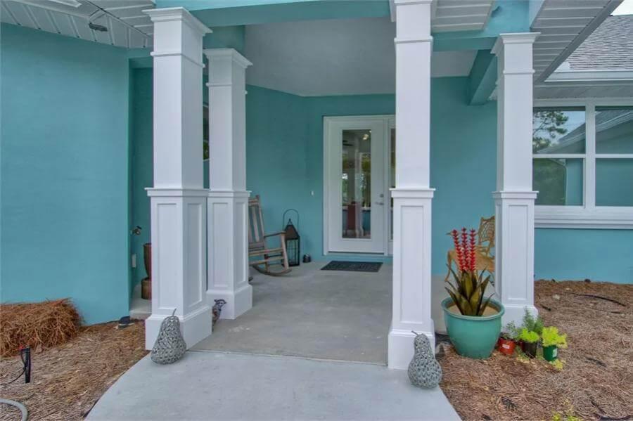 Take a Stroll Up to This Porch with Bold Blue Siding and Crisp White Columns