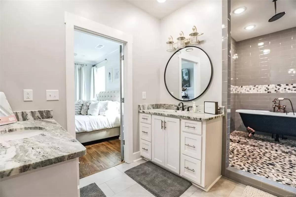 Sophisticated Bath Space with a Standalone Tub and Pebble Tile Accents