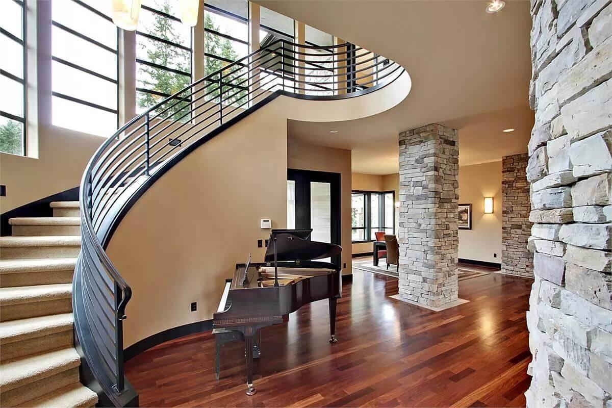 Wow, Check Out the Stunning Curved Staircase Beside the Grand Piano