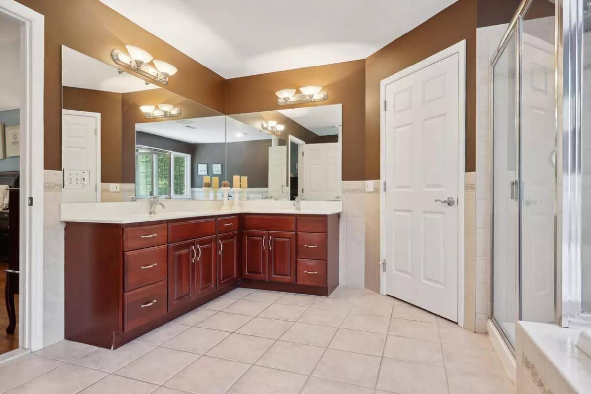 Spacious Bathroom with Rich Wood Vanity and Corner View Shower