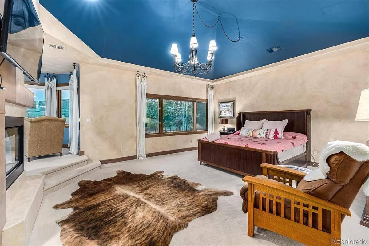 Step Inside This Spacious Master Bedroom with a Bold Blue Ceiling