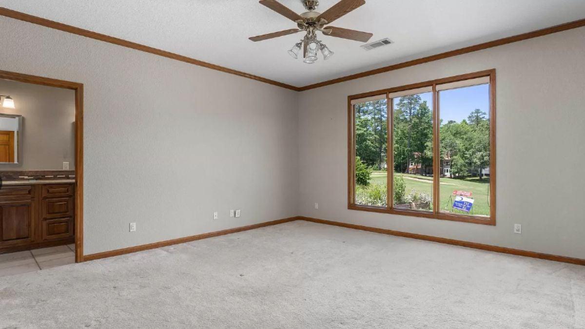 Check Out the Wooden Trim and Ceiling Fan in This Bright Room