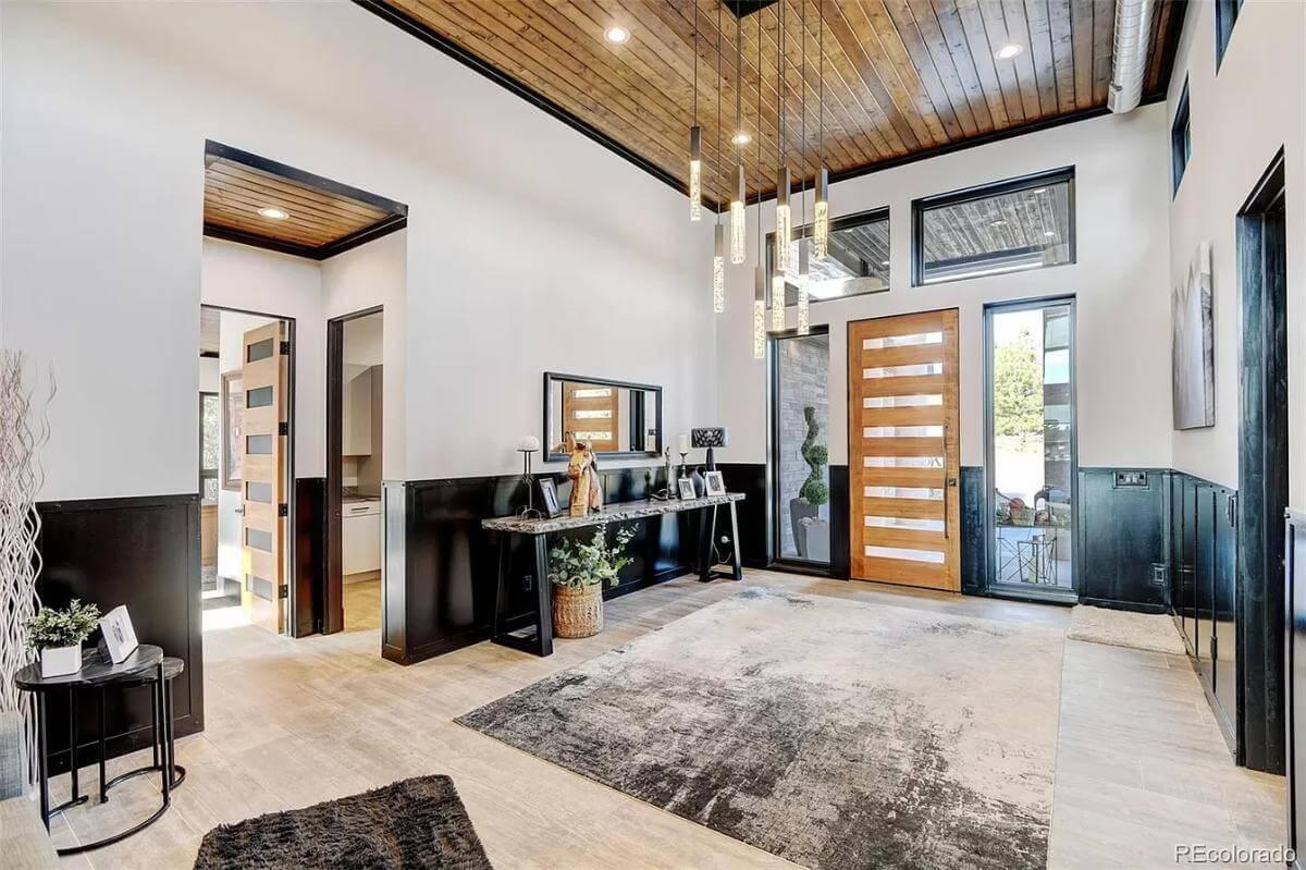 Stylish Entryway with Distinctive Wooden Ceiling and Statement Lighting