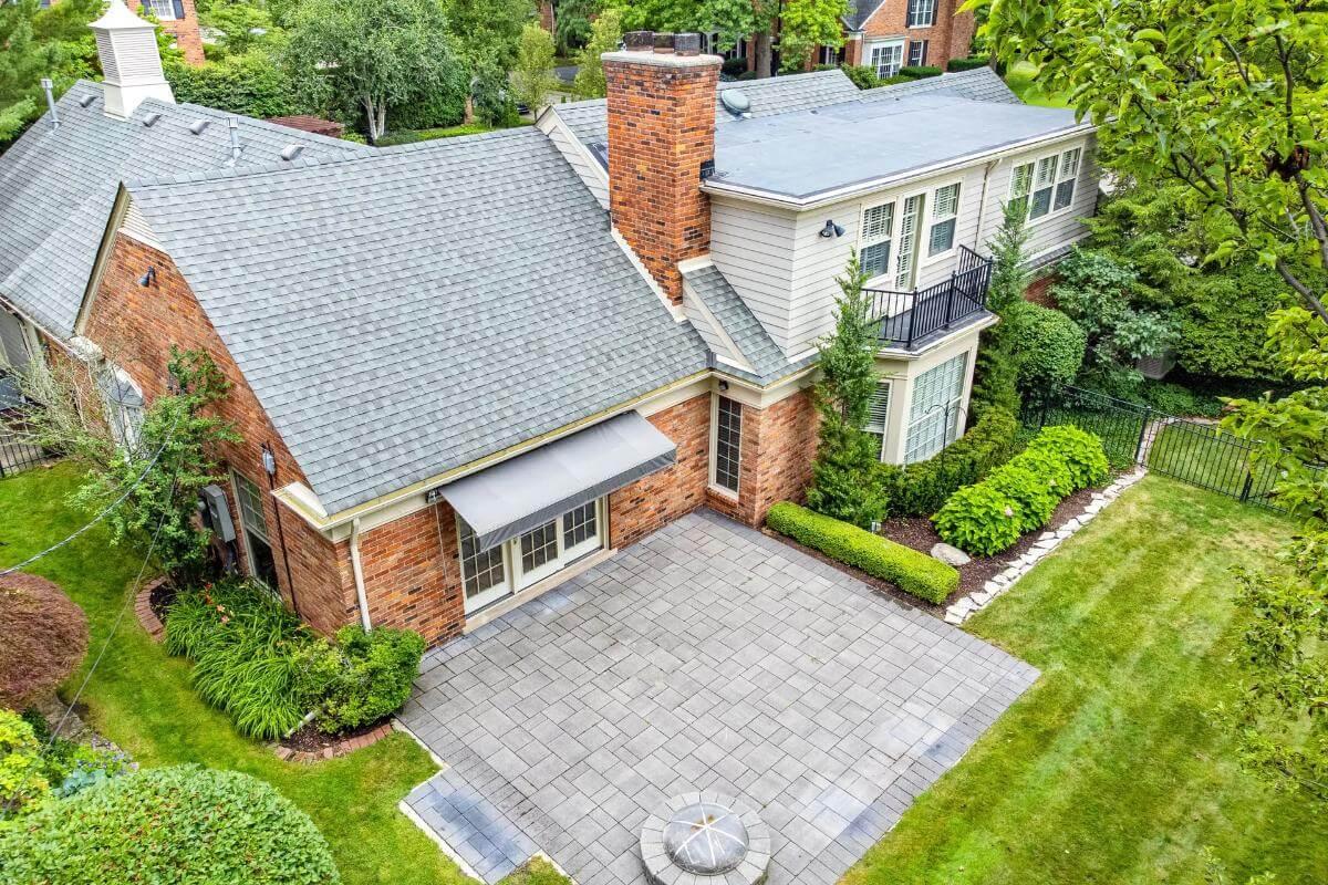 Aerial View of Backyard Patio with Brick Accents and Lush Landscaping