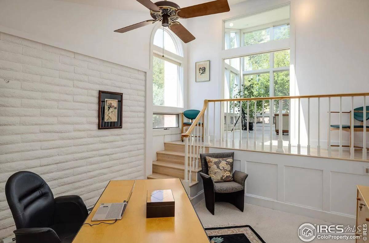 A Home Office Featuring Textured Walls and a Lofty Feel