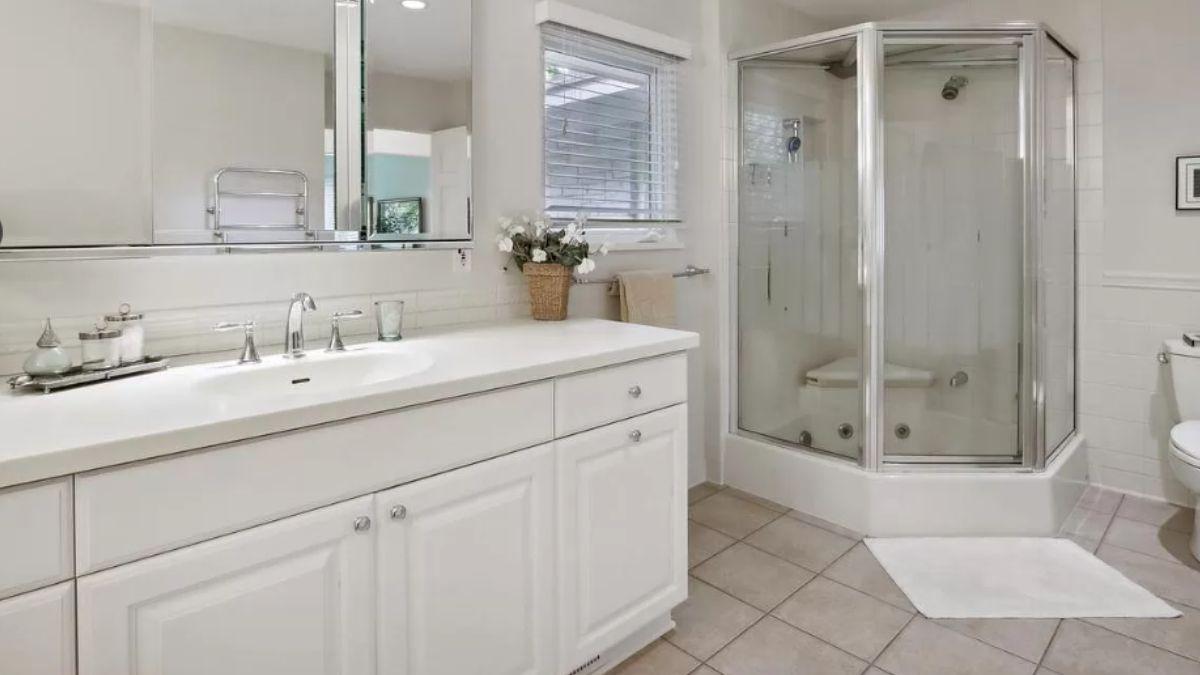 Clean and Practical Bathroom with Corner Shower and Plenty of Light