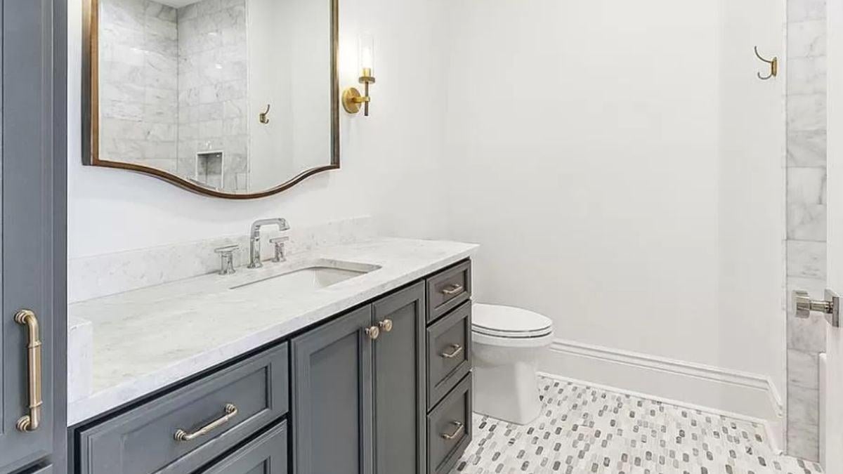 Elegant Bathroom with Brass Accents and Textured Flooring