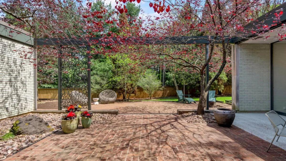 Step Into a Mid-Century Courtyard Under a Canopy of Red Leaves