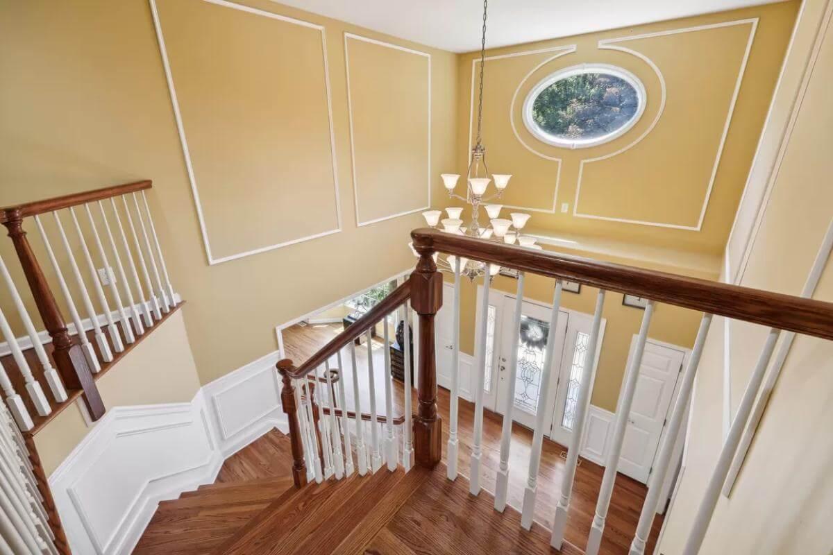 Wow, Notice the Statement Chandelier and Oval Window in This Bright Entryway
