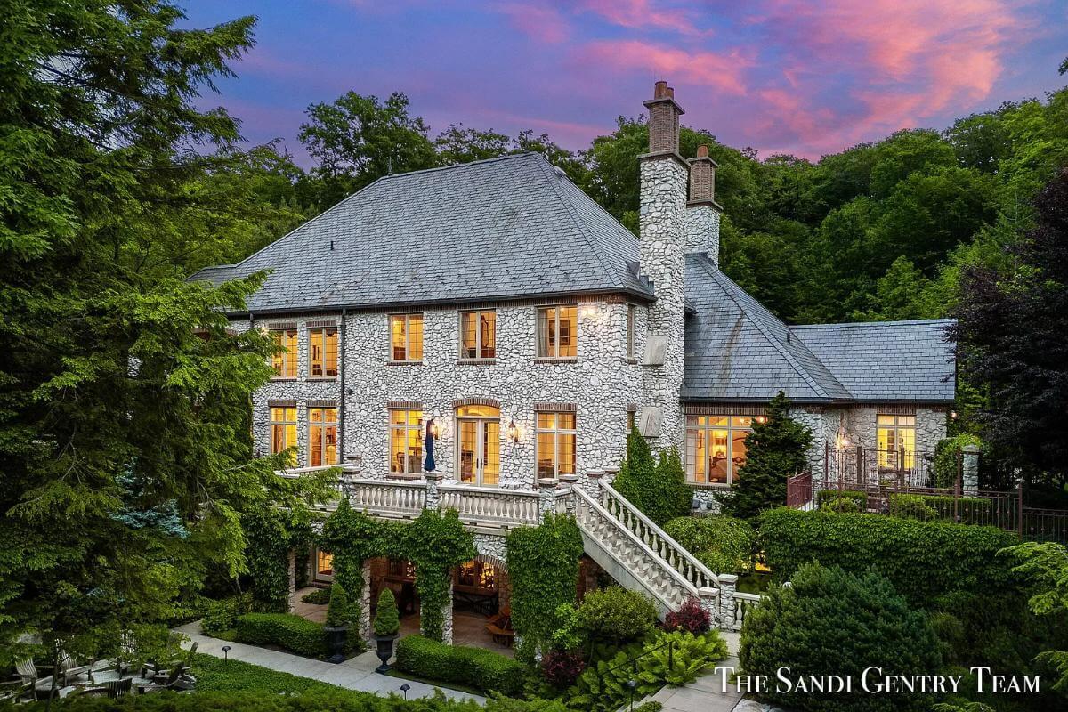 Notice the Grand Stone Facade and Elegant Staircase of This Manor