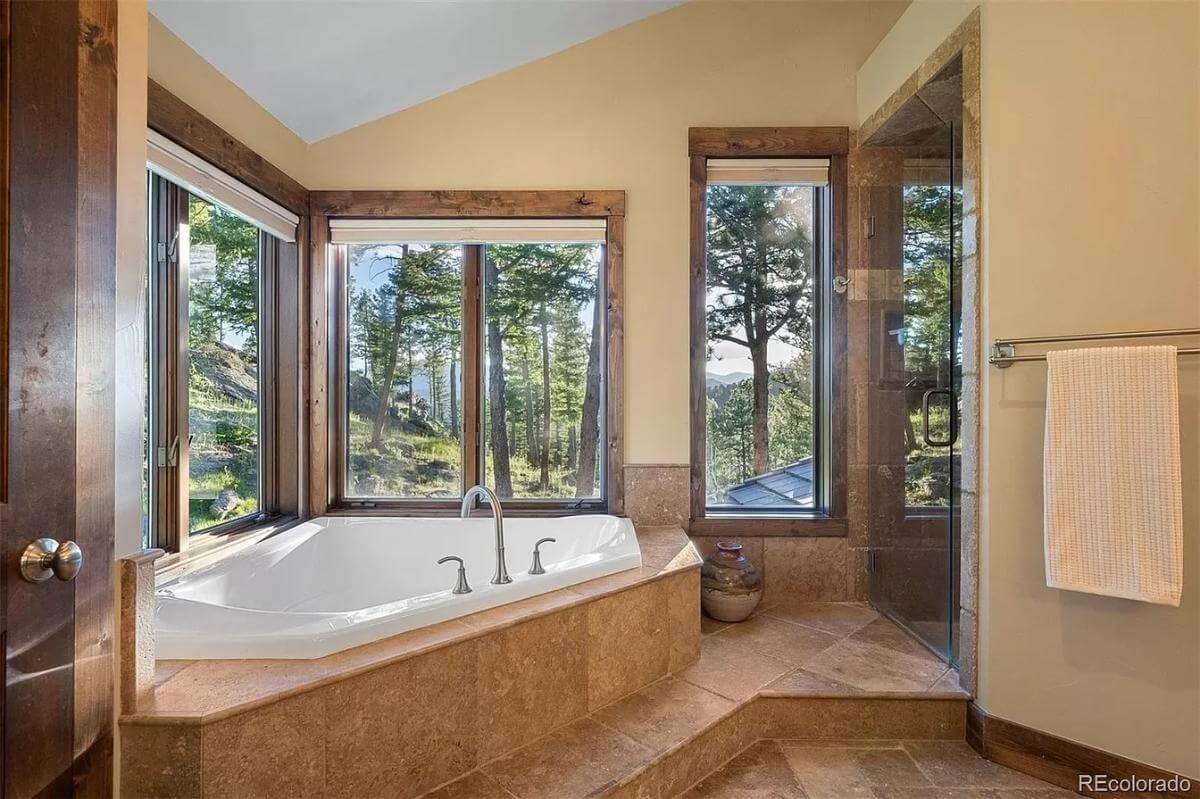 Luxurious Tub with Forest Views Next to Beautiful Stonework