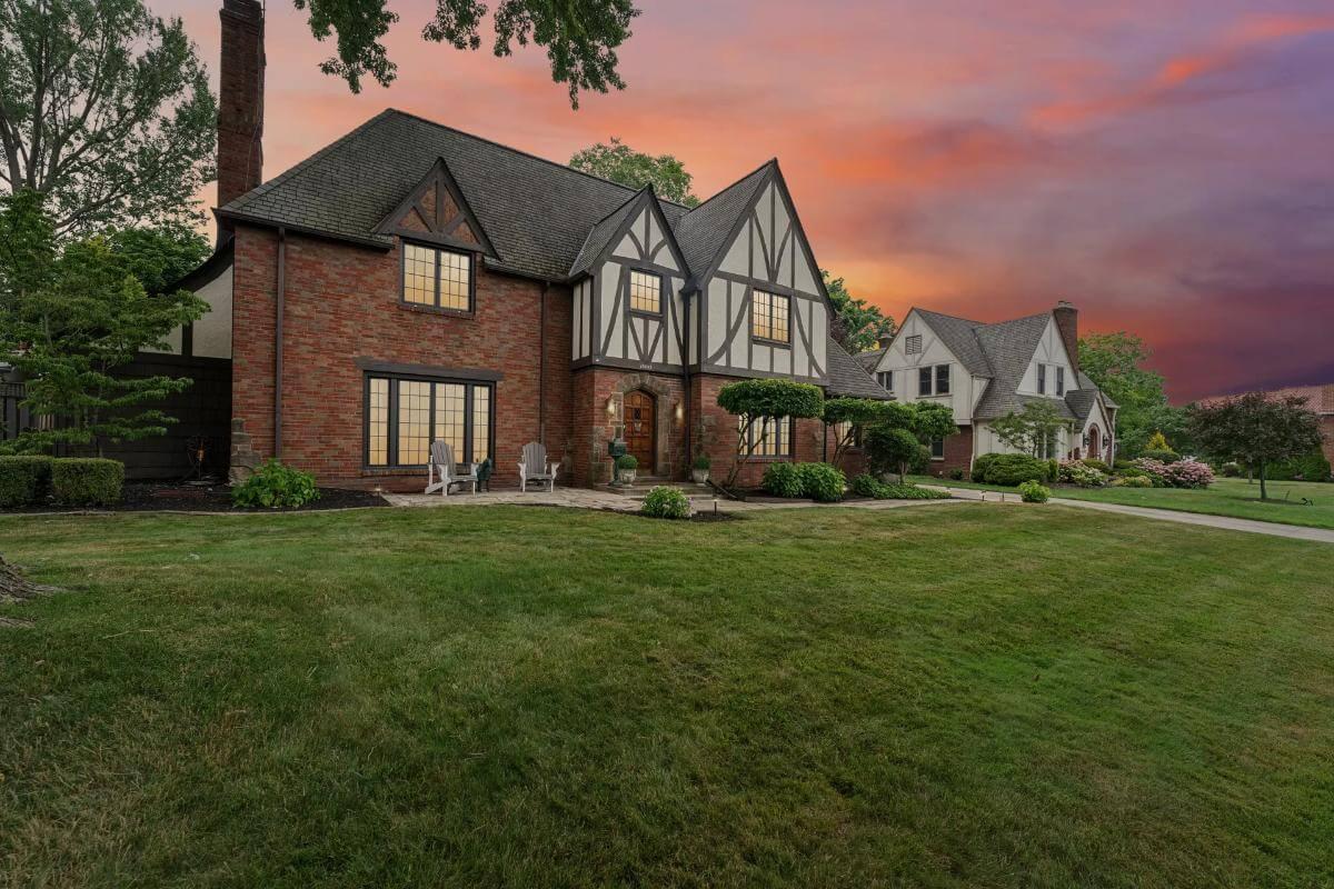 Evening Ambiance with Tudor Revival Charm and Lush Landscaping