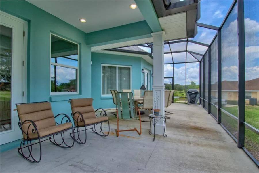 Check Out This Screened Patio with Freestanding Seating for Relaxing Evenings