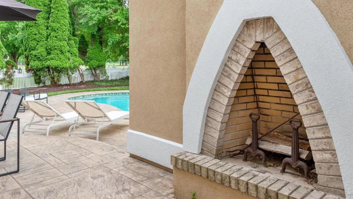 Check Out This Poolside Fireplace with an Eye-Catching Arch