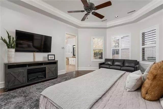 Relax in This Bedroom with a Tray Ceiling and Cozy Fireplace Feature