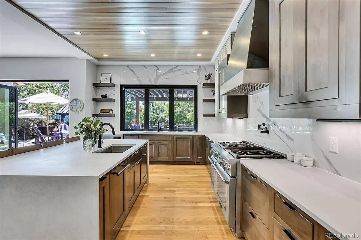 Check Out the Sleek Marble Backsplash and Warm Wood Cabinets in This Modern Kitchen