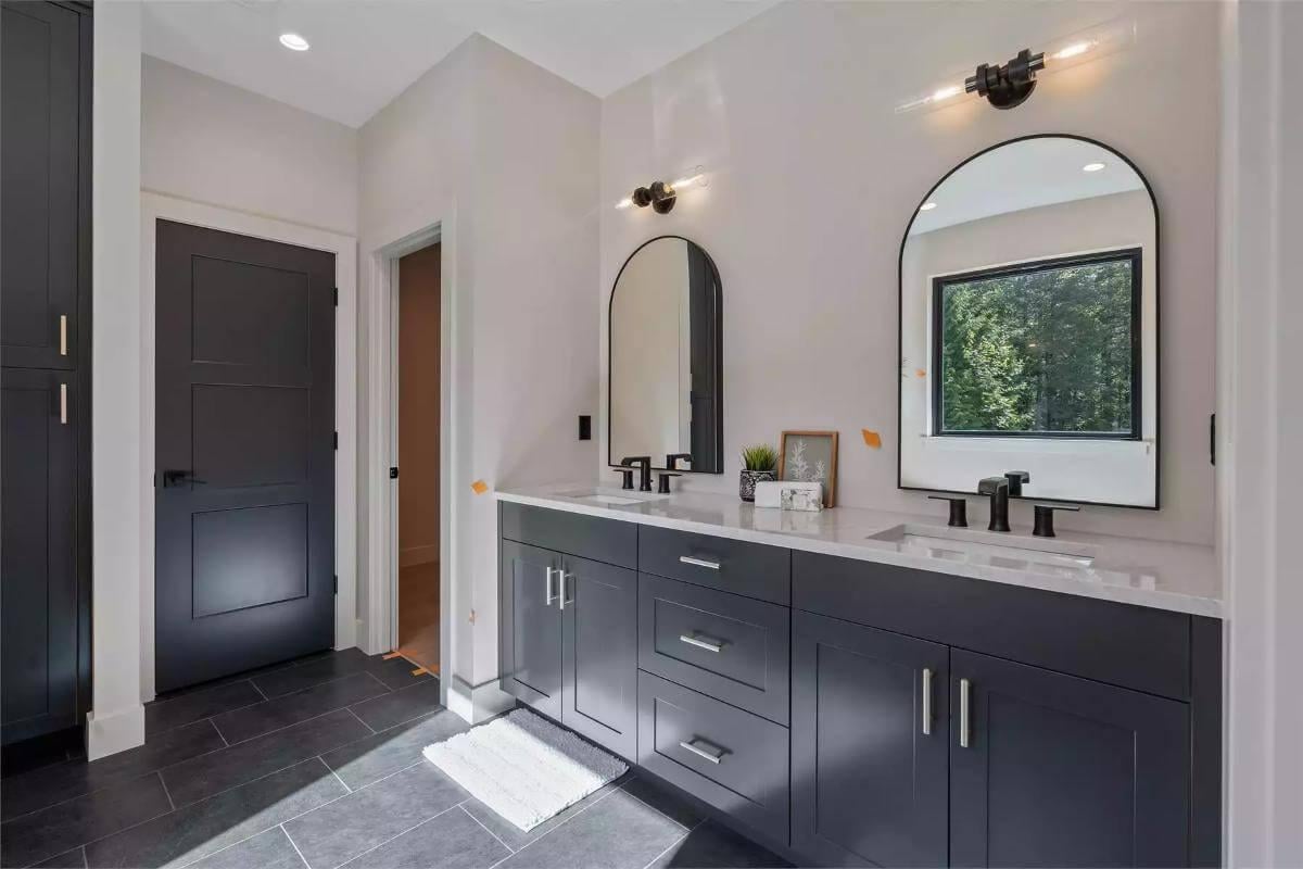 Sleek Bathroom Design with Black Accents and Curved Mirrors
